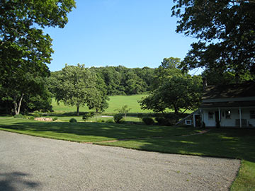 view from front to country lane and bridge across brook