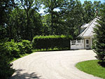 the hornbeam hedge and gates screen the large parking area and garage entrances