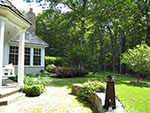 view from the porch towards kitchen deck and hedge at garage end